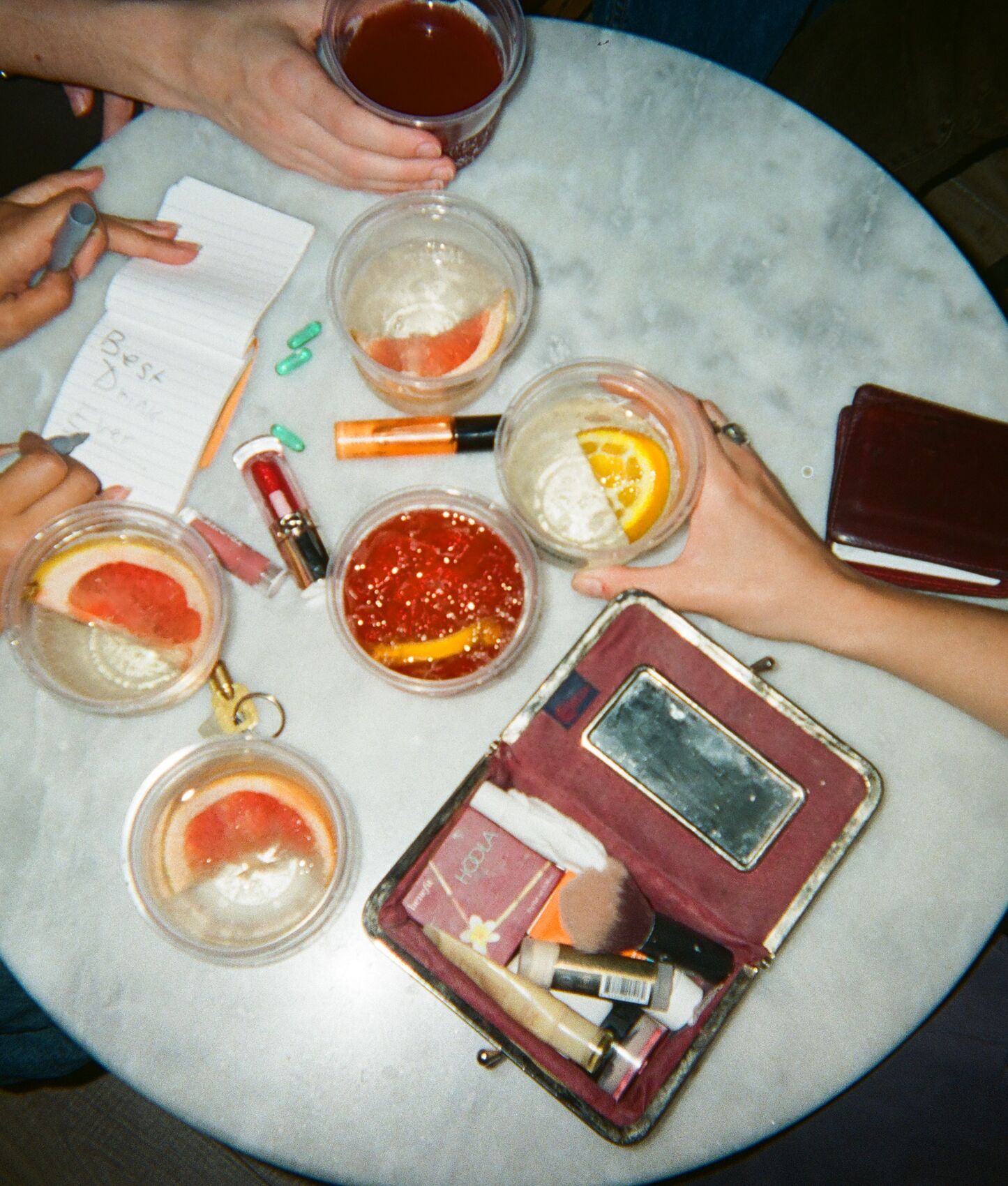 Spritzes with grapefruit and orange on a round marble table, seen from above