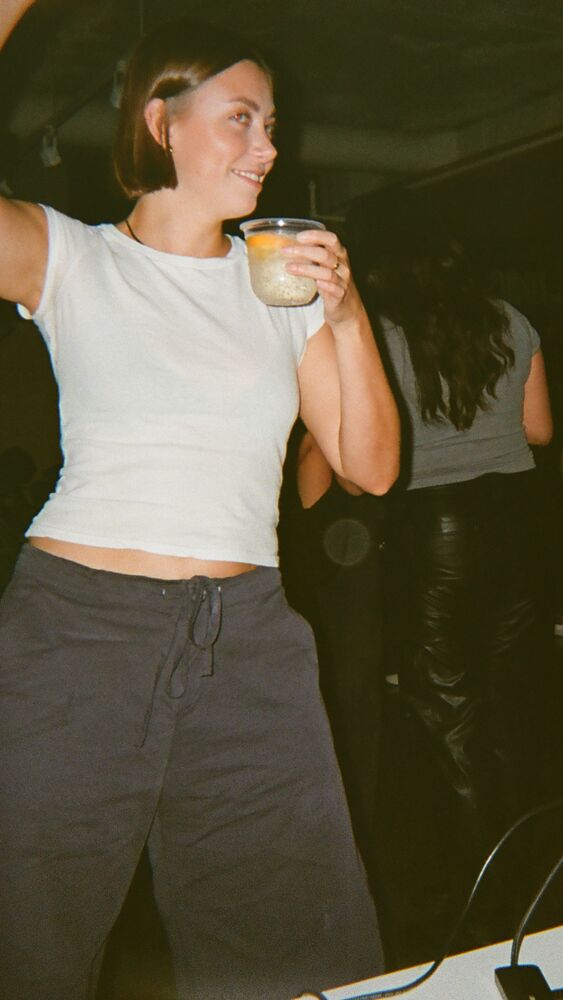 A guest dancing with one arm up and a spritz in hand