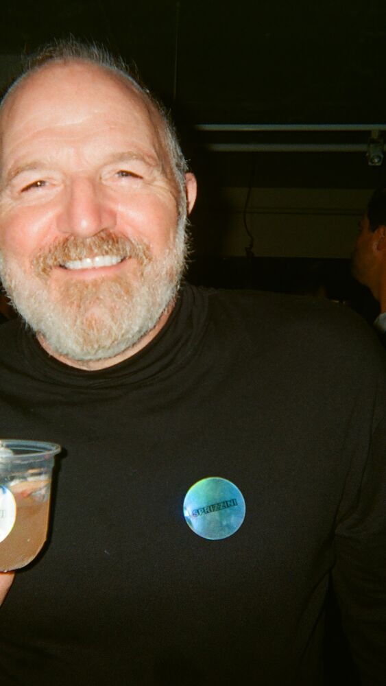 A smiling guest in a Sprizzini sticker